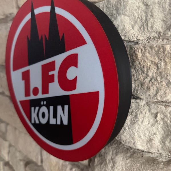 „Beleuchteter Fanartikel des 1. FC Köln in kräftigem Rot und Weiß.“