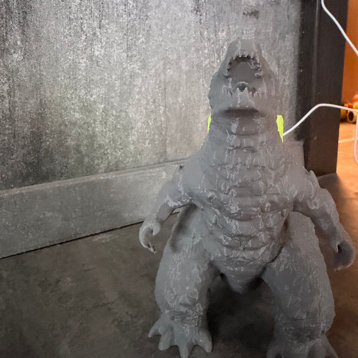 Nahaufnahme der 3D-Druck-Struktur der Godzilla Figur mit LED-Rücken