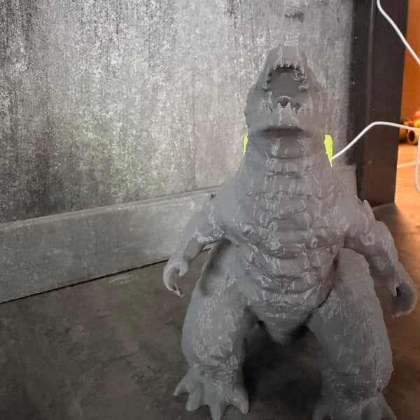 Nahaufnahme der 3D-Druck-Struktur der Godzilla Figur mit LED-Rücken
